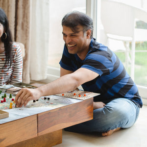 A young man laughs while placing a pawn on the game board of Bharata 600 BC